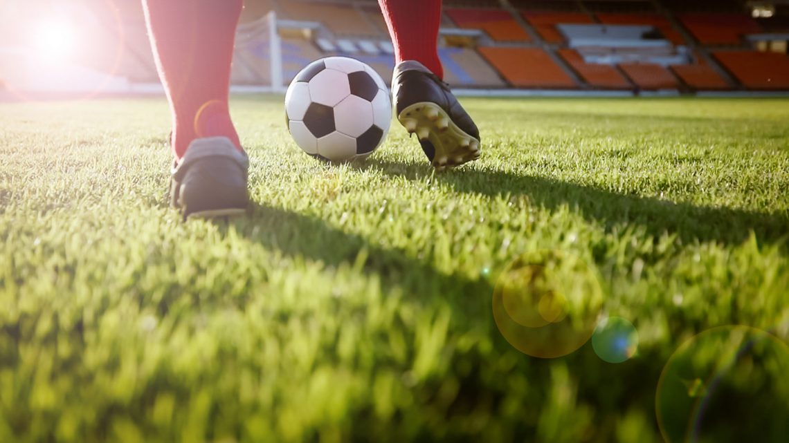 soccer or football player standing with ball on the field for Ki